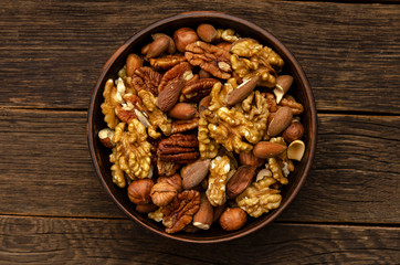 Fototapeta premium hazelnut almonds pecan nuts in bowl on wooden table background.