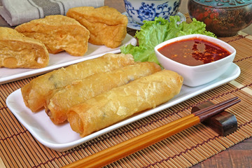 Vegetarian food : Deep fried crispy Spring rolls and fried Tofu, served with sweet and spicy chili sauce. Vegetarian festival. Selective focus