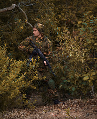 Young warrior with gun in camouflage wear
