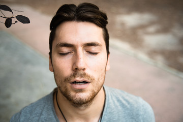 Fototapeta premium Portrait of attractive young male model from above, with closed eyes and concentrated appearance.