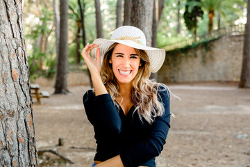 Nice and slim young woman with hat laughing happy looking at camera.