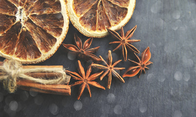 Christmas spices background. Cinnamon, dried oranges and anise on stone background.