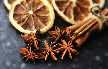 Christmas spices background. Cinnamon, dried oranges and anise on stone background.