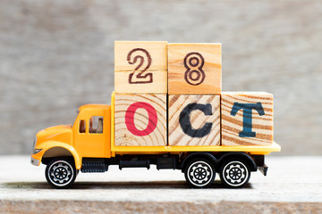 Truck hold letter block in word oct on wood background (Concept for date 28 month October)