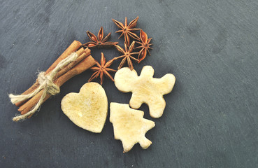 Christmas cookies, cinnamon, dried oranges on wooden background.