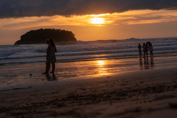 Fototapeta na wymiar silhouettes of people on beach at sunset