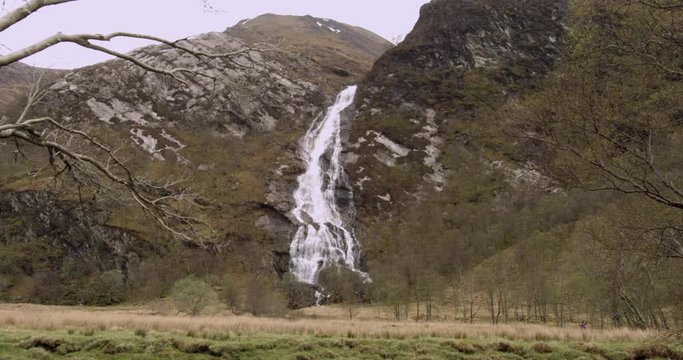 4K The Glen Coe Scottish Mountains. A waterfall through a Beautiful Natural Hillside in rural Tourist Scotland.