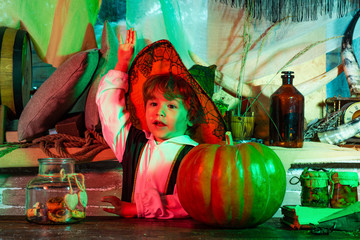 Kids Halloween celebration holiday. Portrait of little boy wearing Halloween costume on home Halloween decorated background.