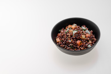 Cooked Sorghum (also known as sorgo) salad or couscous in a back bowl, isolated