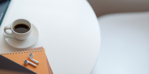 Close-up view of comfortable workspace with copy space and coffee cup on white wooden table