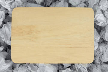 A blank piece of wood on a piece of paper to make a background texture.