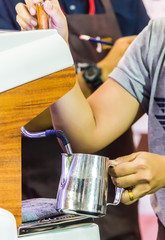 Fototapeta na wymiar Showcase Barista making Latte art coffee and Barista heating milk for making Latte art coffee by Espresso machine.
