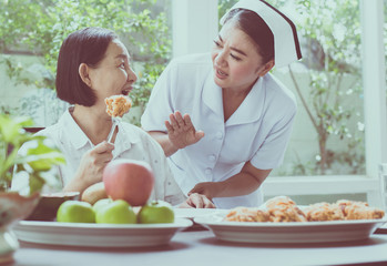 Nurse hands stop to senior Asian woman feeling happy with meal,Elderly healthy concept