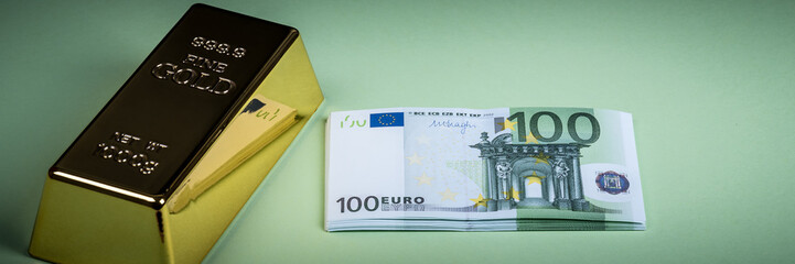 Euro cash and gold bar on a green background. Banknotes. Money. Bill. Ingot. Bullion.