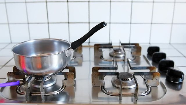 Closeup of flame lighter lighting stove gas in countryside in Italy old retro vintage kitchen stovetop in slow motion