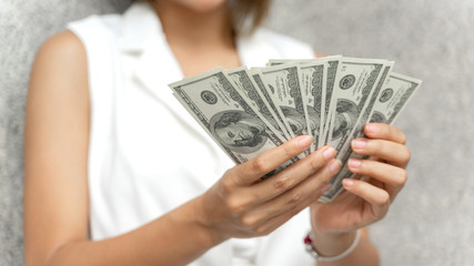 close up woman holding money US dollar bills in hand , business concept