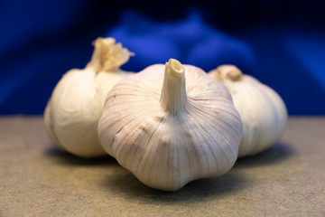 Garlic composition with blue background and brown base