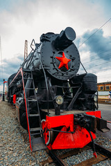 Old black steam locomotive on railway station