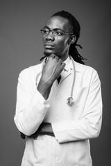 Young handsome African man doctor against brown background