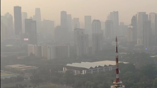 Aerial view of Senayan Sport Complex with TVRI TV Tower in close-up, showing Istora Senayan dan SCBD Complex as background. high polluted air in the morning.