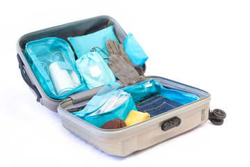 Travel concept with lugage. prepare accessories and travel items isolated on white background. Travel plan, trip vacation, tourism, Open traveler's bag with clothing. Open gray suitcase on the floor.