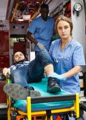 Paramedic team  providing first aid to man