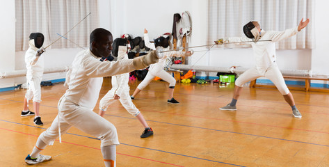 adults and teenagers athletes at fencing workout