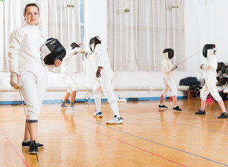 Female fencer standing in gym