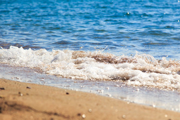 sandy beach and blue sea wave. Beautiful natural background. Tourism and travel.