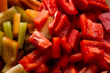 Closeup fresh sweet bell peppers of red and yellow cut cubes, cooking ingredients for a seasonal seasonal vegetable dish