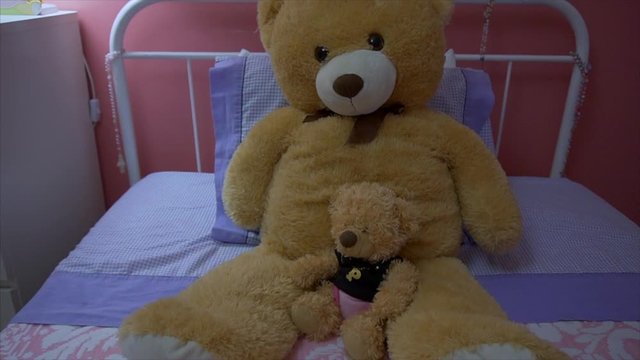 Teddy bear sitting on the bed in a girl's room