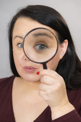 Fototapeta na wymiar Adult woman with magnifying glass