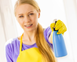 Girl cleaning window at home