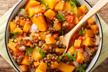 Vegetarian pumpkin curry with lentils, onions and carrots close-up in a bowl. Horizontal top view