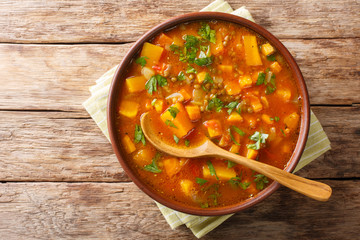 Traditional thick sweet potato soup with lentils close up in a bowl on the table. Horizontal top...