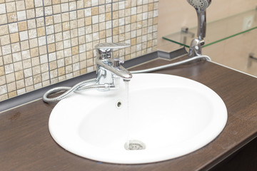 wooden countertop in a modern bathroom white porcelain sink with shower