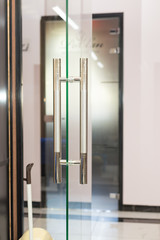 Blank glass door with metal handles. Entrance. Opened luxury hall doorway with transparent surface
