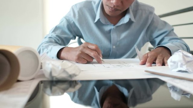 architect interior designer with architectural drawing of house tired exhausted from hard work