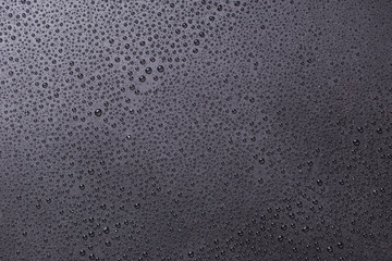 Drops of water close-up on a black matte background.