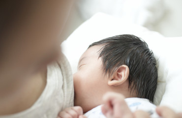 Obraz na płótnie Canvas Mother breastfeeding her newborn baby : Closeup