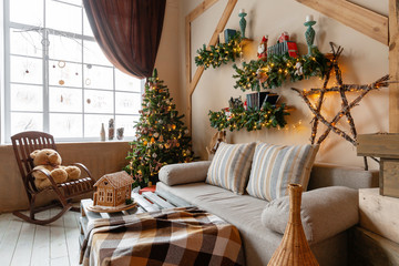 Calm image of interior modern home living room decorated christmas tree and gifts, sofa, table covered with blanket.