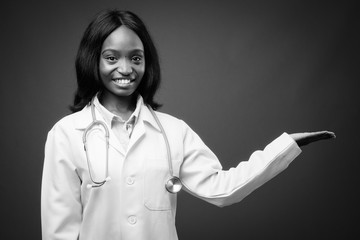 Young beautiful African Zulu woman doctor against brown background