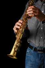 Fototapeta premium soprano saxophone in hands on a black background