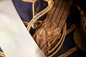Close up picture of the old Italian military uniform with the golden insignia and ribbons. Metal...