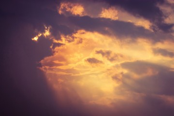 Beautiful natural background, dramatic sky with sunbeams, sun rays shining through the clouds. Soft focus, with copy space.