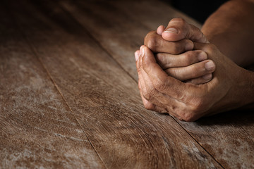 Emotional praying hand holding together on vintage grunge wooden table selective focus