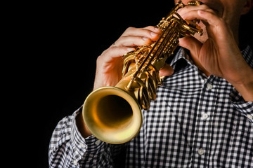 Fototapeta premium soprano saxophone in hands on a black background