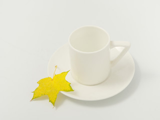 yellow autumn leaves and a cup of coffee on a white background