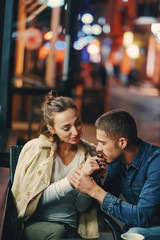 couple drinking coffee outside a restaurant at night