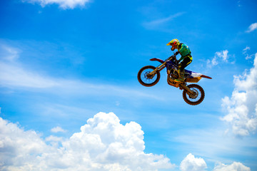 Motocross Rider Jump in a blue sky with clouds.Enduro bike rider in action. 